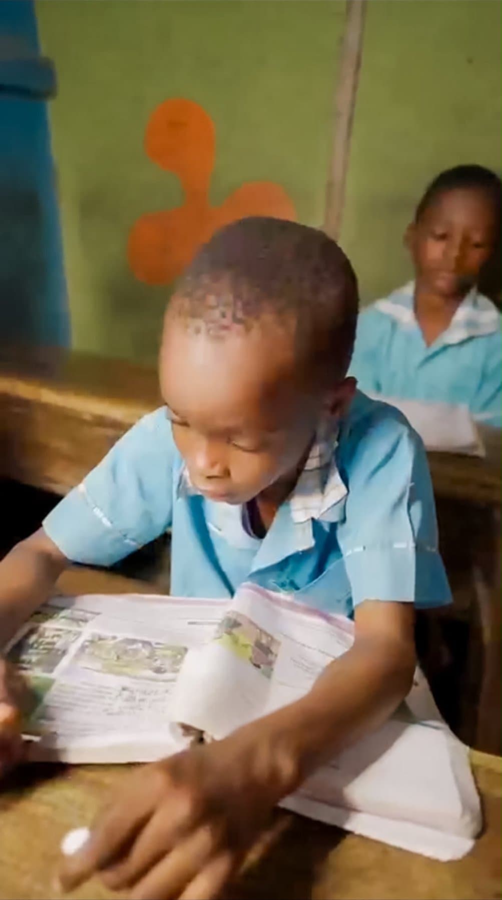 A child reading at his classroom desk